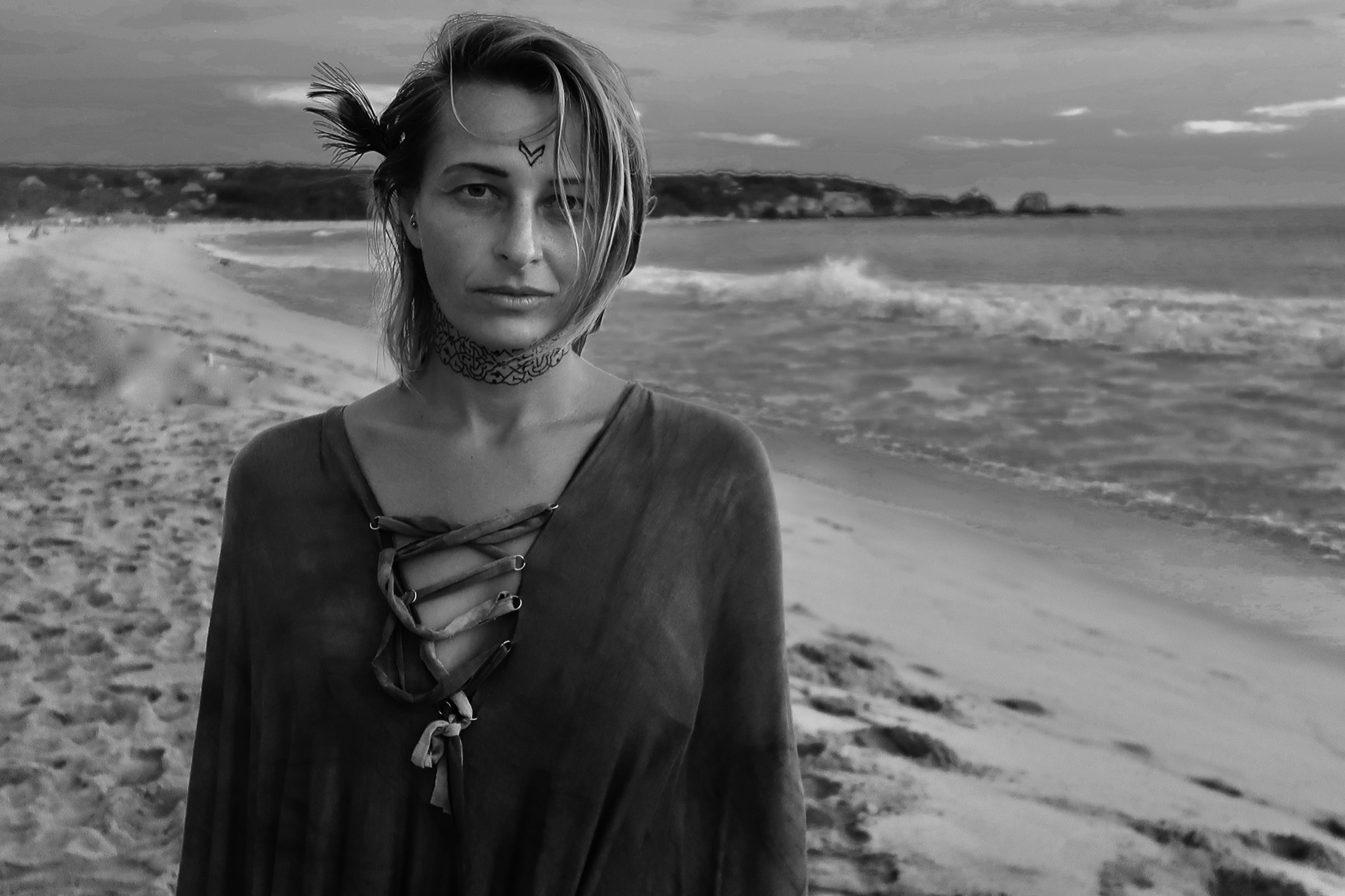 Black and white portrait of Amandine standing on a beach.