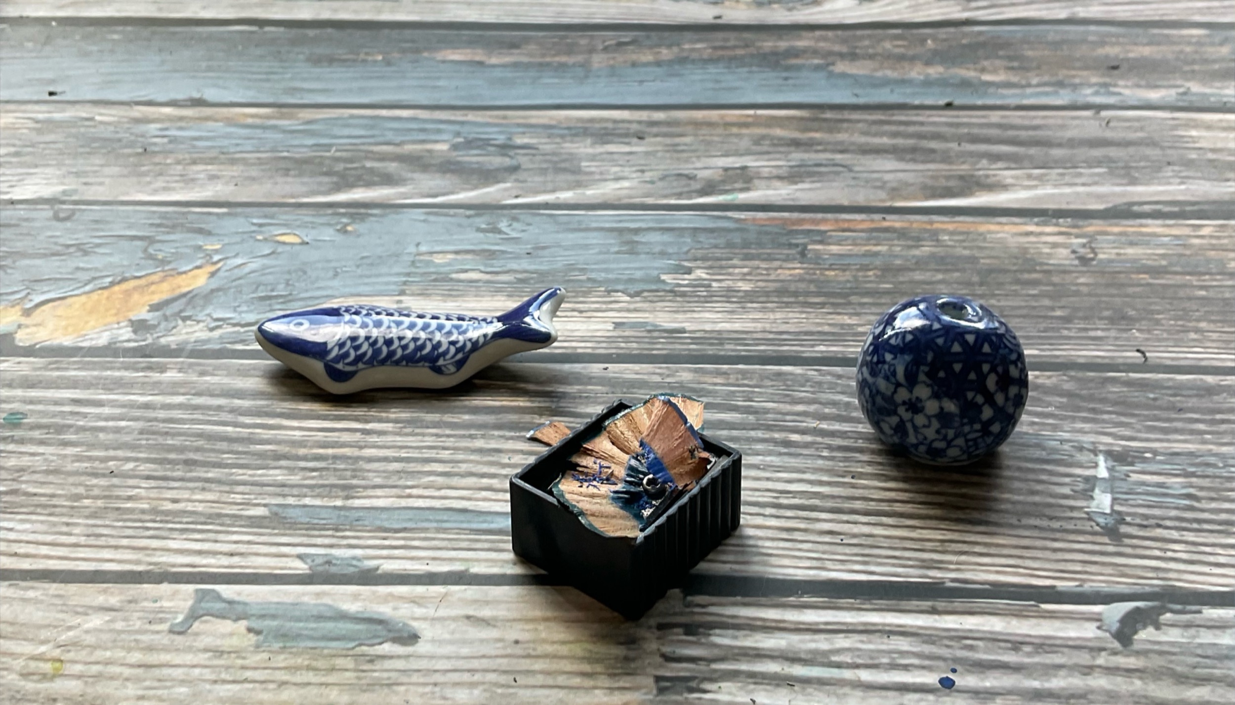 Small blue ceramic objects arranged on a weathered tabletop.